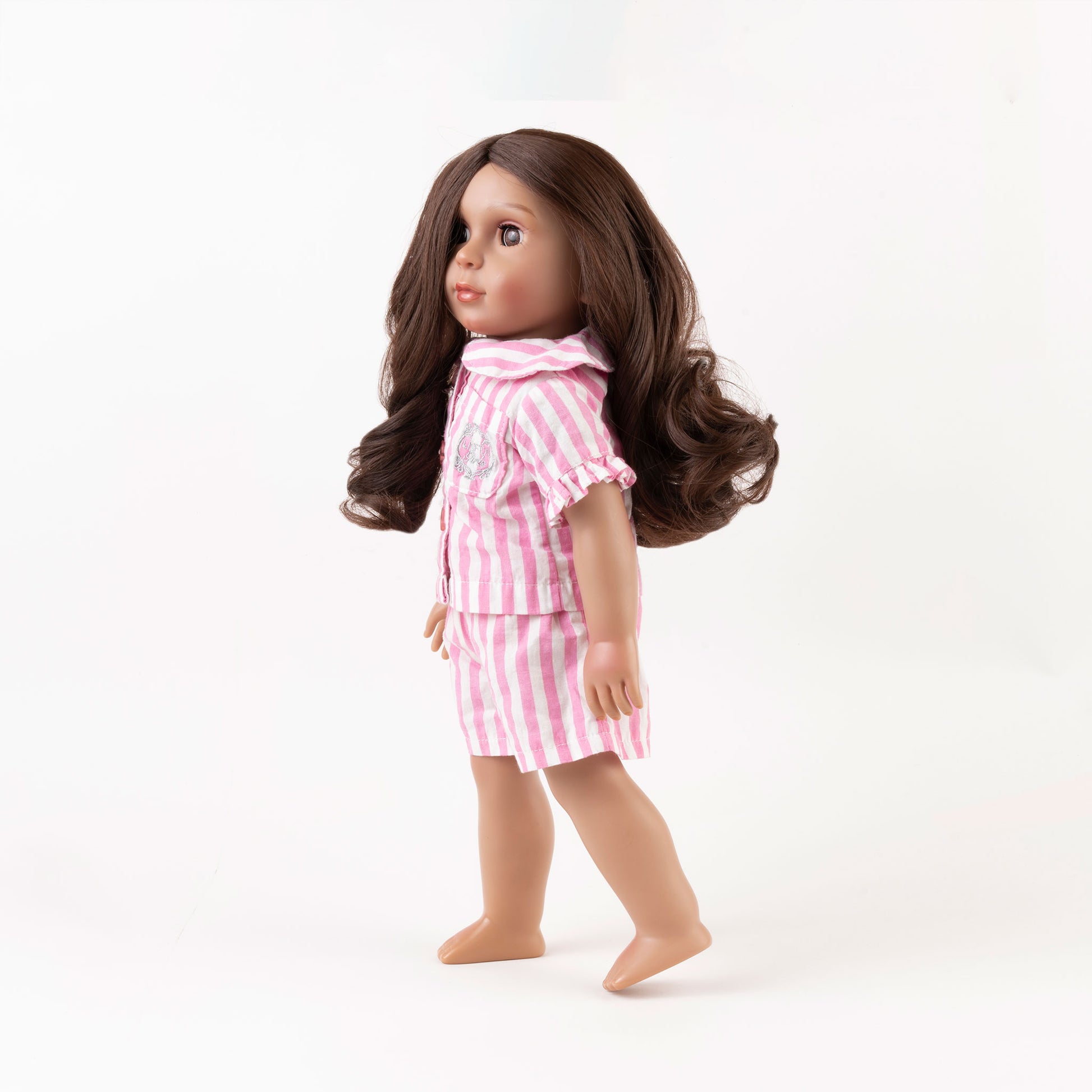 Picture of Yasmeen, the Little Me Doll, wearing pink and white stripped short Pajamas, standing up and looking slightly to the left